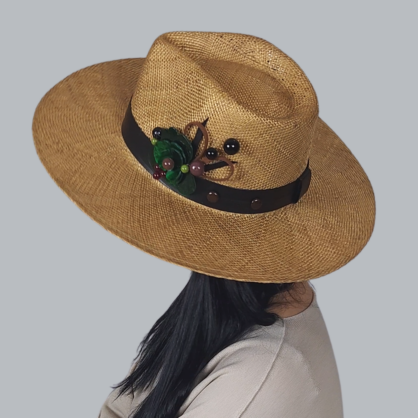 Brown Straw Fedora Hat with Brooch close up view of the brooch with leather ribbon and trim a little at the back