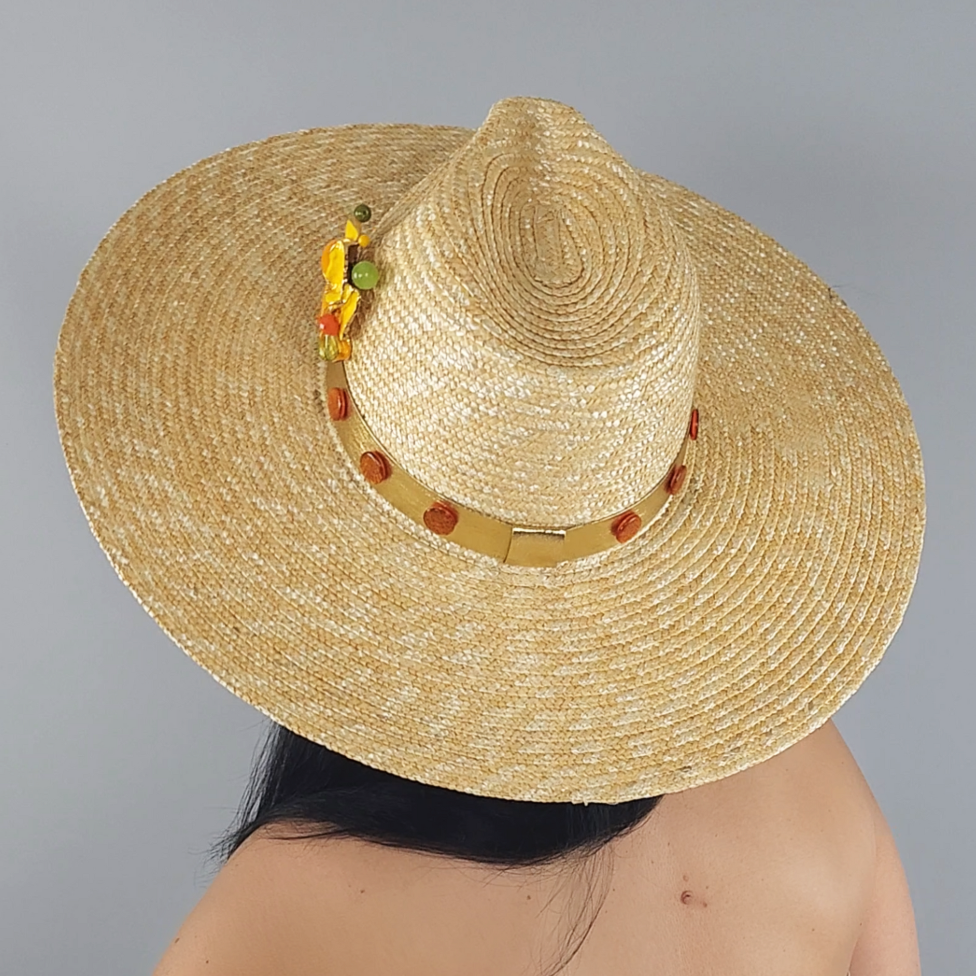 Golden Straw Fedora Hat with Yellow Flower Brooch close-up view from behind